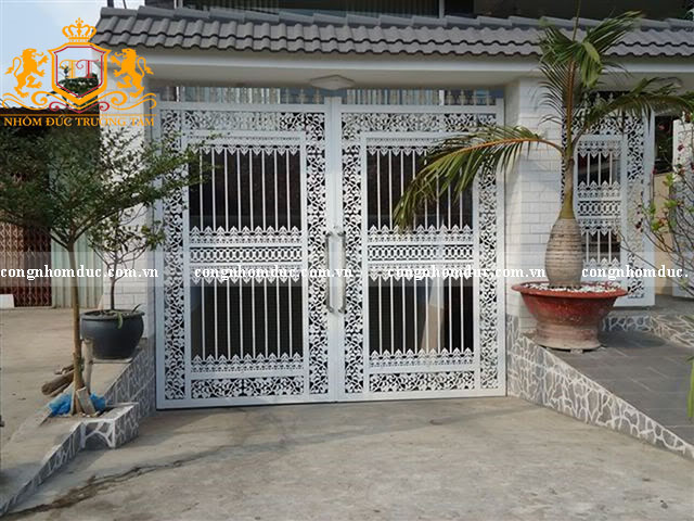 Đây là mẫu cổng nhà ở nông thôn thích hợp dành cho gia chủ yêu thích phong cách tỉ mỉ với sự kết hợp giữa 2 phong cách hiện đại và cổ điển. Hoa văn uốn lượn vô cùng tinh tế. Màu trắng của bộ cổng kết hợp hài hòa với tông màu chủ đạo của ngôi nhà. 