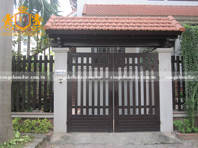 Đây là mẫu cổng chẳng quá xa lạ ở khu vực nông thôn. Mặc dù nó được thiết kế khá đơn giản nhưng vẫn tạo được nét thu hút riêng. Thiết kế được mô phỏng hang rào kết hợp chi tiết đinh ốc ghim trên các thành làm cho bộ cổng bớt đơn điệu.