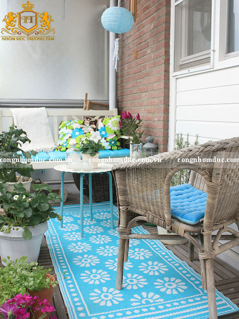 2. Một chiếc thảm trải sàn màu xanh chắc chắn sẽ có sự ảnh hưởng rất lớn đối với 1 ban công có sự xuất hiện của nhiều yếu tố thiên nhiên. Nó góp phần tạo nên 1 không gian hoàn hảo. Những sắc màu tràn đầy năng lượng của tấm trải sàn cùng với đệm ghế tạo ra sự tương phản rõ rệt với những bức gạch khô. Quả là xuất sắc đúng không ạ?